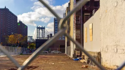 View of vacant lot in Manhattan through chain link fence
