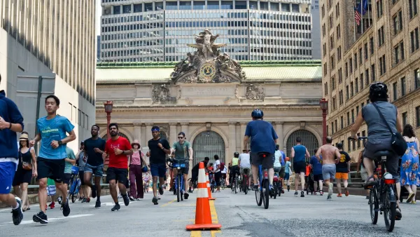People walking and biking on street in front of Grand Central Terminal in New York City.