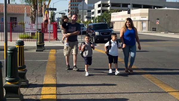 Family with three small children crossing the street in Bakersfield, California.