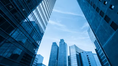Blueish tinged shot looking up at modern glass office buildings