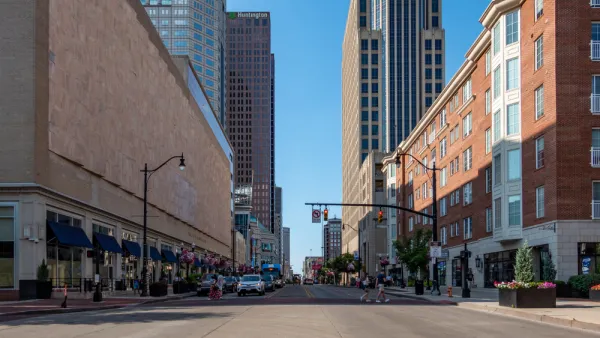 Broad street in downtown Columbus, Ohio with two pedestrians in crosswalk