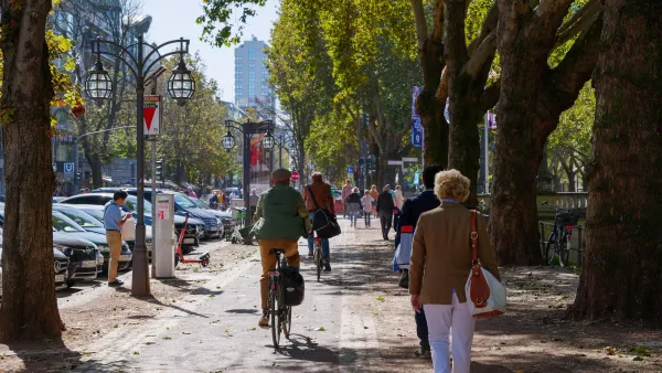 People walking and biking on sidewalk in Dusseldorf, Germany.