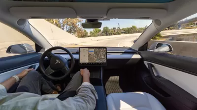 Interior of Tesla car with driver holding hands off wheel in 'full self-driving' mode