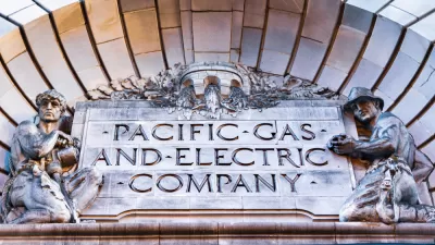 Close-up of Pacific Gas & Electric Company title carved into building facade, flanked by two statues of utility workers