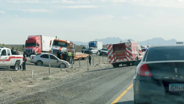 Cars crashed inthe middle of a dirt highway median.