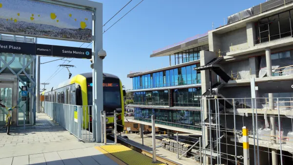 Yellow and black light rail train pulling into elevated station in Culver City, California.