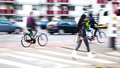 Pedestrians and cyclists in busy city crosswalk with blurred motion