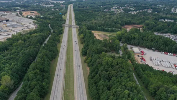 Aerial view of freeway cutting through green forest in Clayton County, Georgia