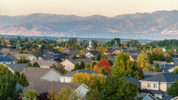 View of residential neighborhood with large trees and mountains in background in Salt Lake City, Utah.
