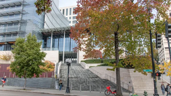 Seattle City Hall facade with stairs up to building and red and orange fall leaves on trees.