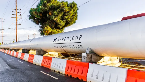 Hyperloop test tunnel on street with orange and white concrete barriers 