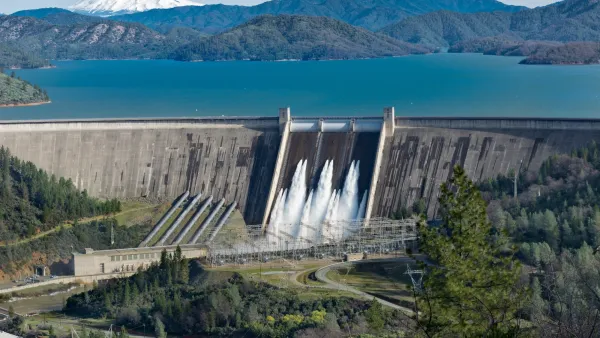 Shasta Dam with deep turquoise water in reservoir behind it in northern California.