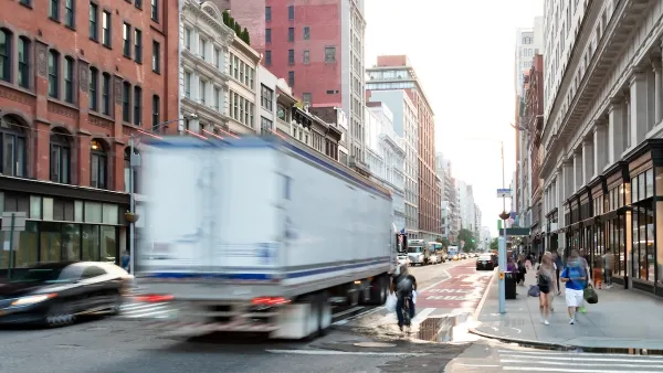 Blurred white truck driving down New York City street with blurred cyclist next to it.