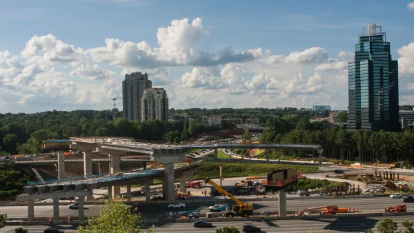 Highway overpasses eith four high-rise buildings sparsely arranged in background in Atlanta, Georgia.