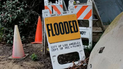 Sandwich sign with "Flooded" and "CIty of Los Angeles Dept of Rec and Parks" sits in ground near orange traffic cone