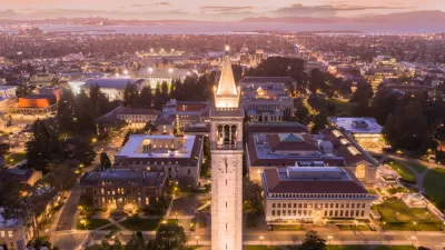 Aerial view at dusk of UC Berkeley campus with tall tower in foreground and San Francisco Bay in the background
