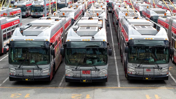White San Francisco transit buses parked in a large lot.