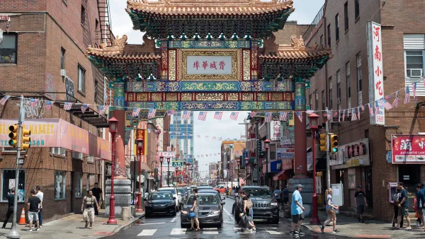 Ornate Chinatown gate in Philadelphia, Pennsylvania with people walking in front of it.