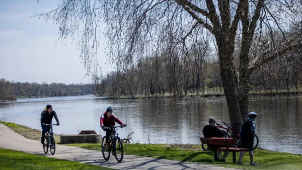 Two cyclists biking on paved trail past lake in Chicago, Illinois.