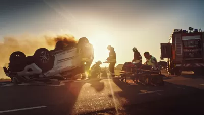 OVerturned vehicle with fire truck and firefighters assisting