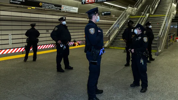 Group of NYC transit police officers stand in subway station wearing blue surgical masks.