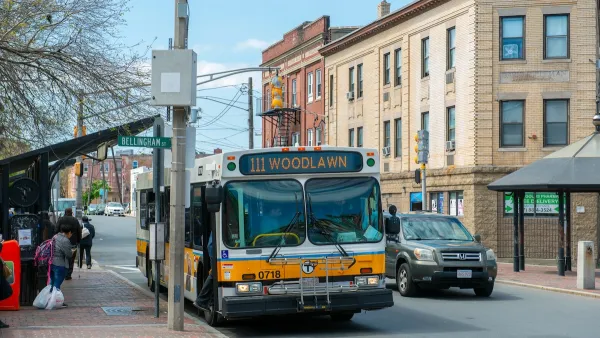 An MBTA bus picks up people from a bus stop.