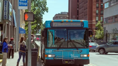 Bus stop in Pittsburgh, Pennsylvania with blue bus and passengers boarding