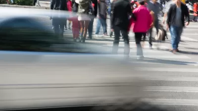People in crosswalk with blurred fast car passing in foreground