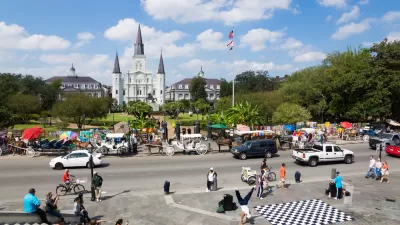 View of Jackson Square, New Orleans with cathedral and street dancers in foreground