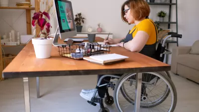 Woman in wheelchair working at a home office desk