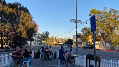 Outdoor dining patio in street in Echo Park neighborhood of Los Angeles, surrounded by white picket fence