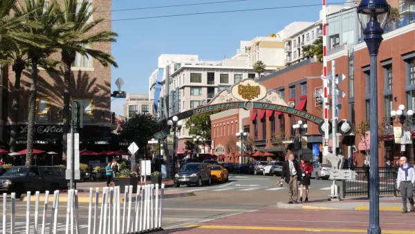 Crosswalk in San Diego with Gaslamp District decorative arch sign over street.