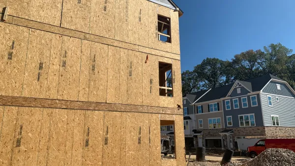 Wood-frame three-story building under construction.