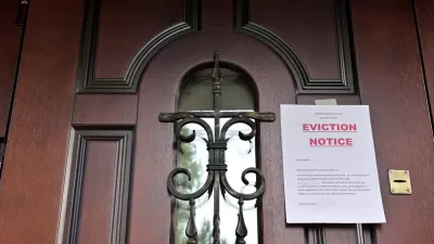 Eviction Notice taped to brown wooden door with black iron details