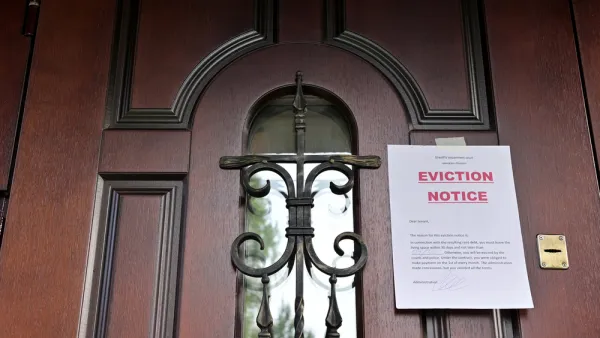 Eviction Notice taped to brown wooden door with black iron details