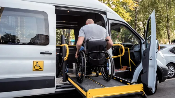 Man in wheelchair entering paratransit van on ramp.