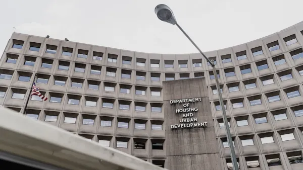 A view from below the HUD. The building is gray with a grid of windows.