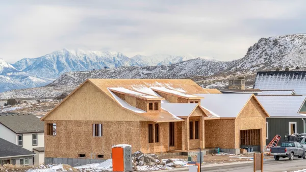 Wood-framed single-story home under construction in snowy landscape in southern Utah.
