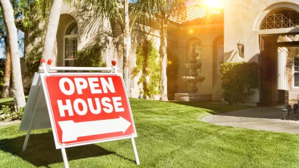 Red and white "Open House" sign on lawn in front of faux Spanish-style home with fountain in front.