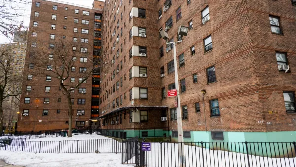 Multistory red brick apartment building in New York City with snow on the ground.