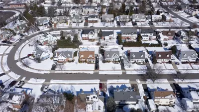 Aerial view of snowy single-family homes in suburban Long Island, New York
