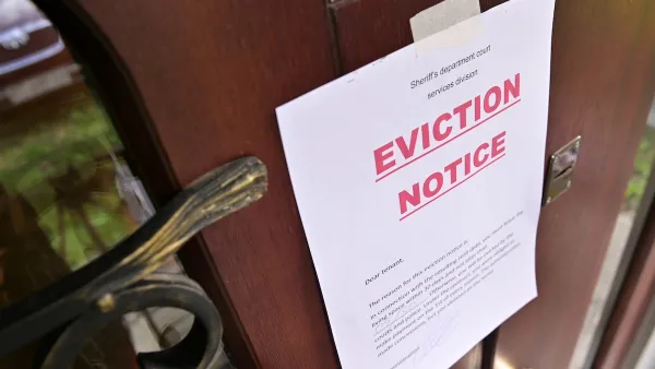Eviction notice with bold red "Eviction Notice" text taped to brown wooden door.