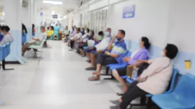 Blur image of patients in a hospital waiting area.