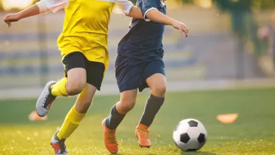 Two soccer players chasing a ball