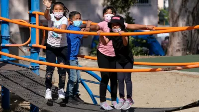 Children wearing COVID-19 masks on playground equipment