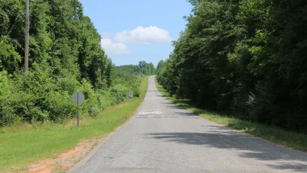 Empty two-lane rural road in Alabama with forest on both sides.