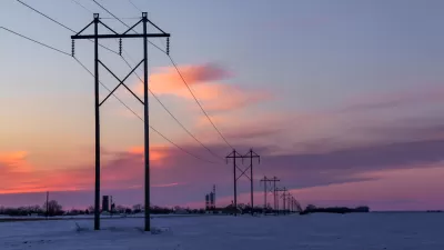 Power lines against sunset sky and snowy landscape in rural Minnesota