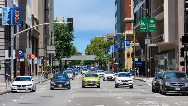 Head-on view of cars stopped at intersection on one-way street in San Francisco, California on a sunny day.