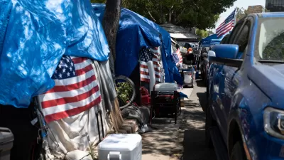 Line of tents with American flags draped on them on sidewalk in Los Angeles