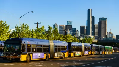 Seattle buses in line at a depot with Seattle skyline in background